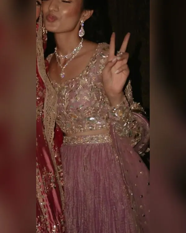 Model wearing a rose pink embellished lehenga choli